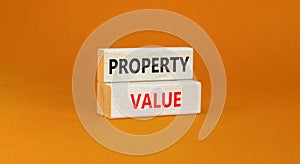 Property value symbol. Concept words Property value on beautiful wooden blocks. Beautiful orange table orange background. Business