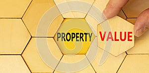 Property value symbol. Concept words Property value on beautiful wooden puzzle. Beautiful yellow table yellow background.