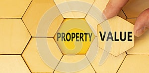 Property value symbol. Concept words Property value on beautiful wooden puzzle. Beautiful yellow table yellow background.
