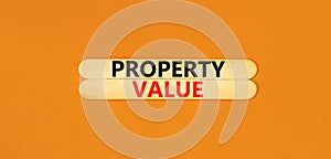 Property value symbol. Concept words Property value on beautiful wooden stick. Beautiful orange table orange background. Business