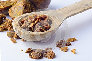 Propolis granules in a wooden spoon. Bee glue. Bee products. Apitherapy. Apiculture.