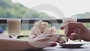 A proposal of marriage. Close-up of a man`s hand puts on a gold ring to his beloved and future wife.