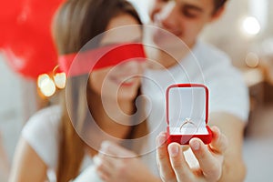 Proposal ring in red box.Love, couple, proposal and people concept - happy man giving diamond engagement ring in little red box to