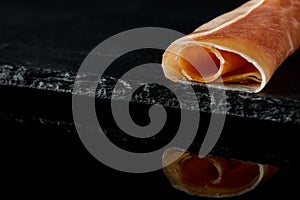 Prosciutto on a black background