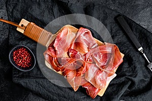 Prosciutto crudo, italian salami, parma ham. Antipasto plate. Black background, top view photo
