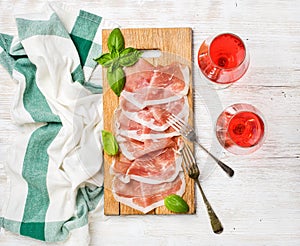 Prosciutto di Parma ham slices and rose wine glasses