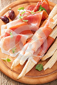 Prosciutto ham and grissini bread sticks. italian antipasto