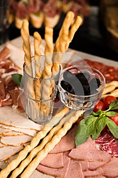 Prosciutto and meat assorted. Breadsticks with meat slicing. Close up shot. Holiday or event treats. Catering food