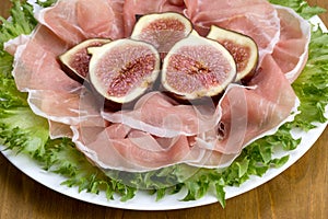 Prosciutto served with figs on lettuce leaves