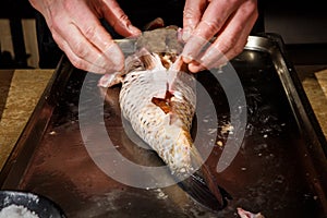 proses of stuffing big fish by chef hands photo