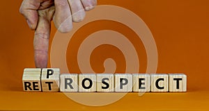 Prospect or retrospect symbol. Businessman turns wooden cubes and changes the word `retrospect` to `prospect`. Beautiful orang