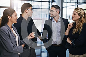 The prospects of success are always high in this team. a group of businesspeople having a discussion in an office.