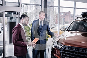 Prosperous man buying new car for his wife for her birthday