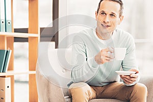 Prosperous business man drinking tea during meeting photo