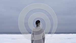 Prosperous young businessman standing in field covered in snow