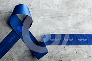 Prostate Cancer Awareness Campaign Concept. Men Healthcare. Close up of a Blue Moustache Ribbon Lying on Rough Grey Cement