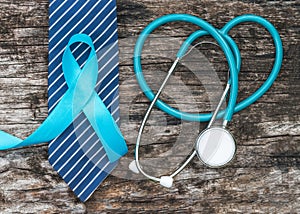 Prostate cancer awareness concept with light blue ribbon on necktie and old aged wood for men`s health care campaign in November