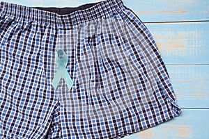Prostate Cancer Awareness, light Blue Ribbon with male underpants on blue wooden background