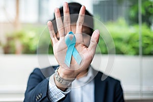 Prostate Cancer Awareness month, Business Man holding light Blue Ribbon with mustache for supporting people living and illness. Me