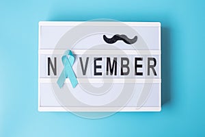 Prostate Cancer Awareness month, Light blue Ribbon with mustache on lightbox with November text background for supporting people