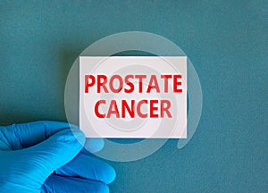 Prostate cancer symbol. White note with words Prostate cancer, beautiful blue background, doctor hand in blue glove. Medical and