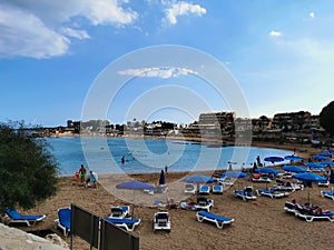 Protaras. Famagusta area. Cyprus. Sandy Kalamies beach with sun loungers and parasols in the bay of the Mediterranean Sea in the