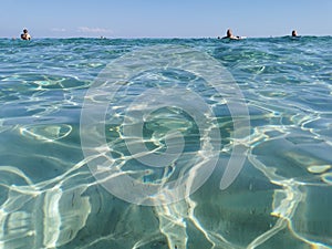 Protaras. Famagusta area. Cyprus. Crystal clear, blue, clear water of the Mediterranean Sea on Sunrise beach, people swim