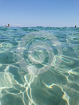 Protaras. Famagusta area. Cyprus. Crystal clear, blue, clear water of the Mediterranean Sea on Sunrise beach, people swim