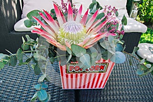A protea flower bouquet in a popcorn bucket