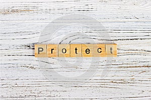 PROTECT word on block concept. PROTECT word made with wooden blocks on the table photo