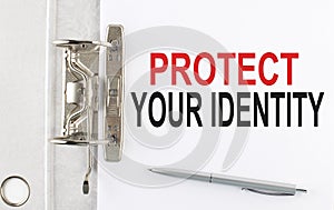 PROTECT YOUR IDENTITY text on the paper folder with pen. Business concept