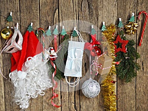 Protect yourself from the coronavirus at Christmas. Santa Claus hat and Christmas tree decorations hang on clothespins on a rope