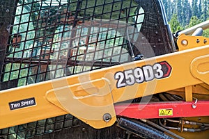 The protected cab and hydraulic arm of a Caterpillar 259D3 track loader in Idaho, USA - July 30, 2021