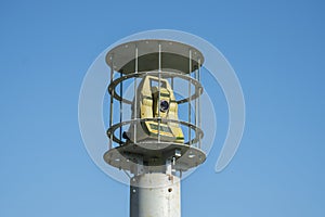 Protected outdoor security camera against a blue sky. opy space