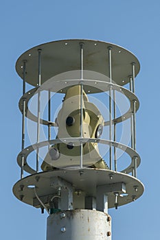 Protected outdoor security camera against a blue sky. opy space. vertical photo