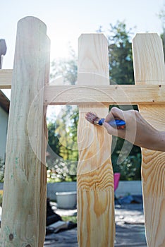 Protecting backyard wooden fence with transparent varnish