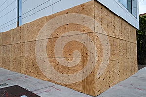 Protecting the building from a hurricane and robbers. Plywood on the wall of a building.