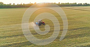 Protecting fields from pests. Large wheat field drone view. A tractor sprays a wheat field, a top view.