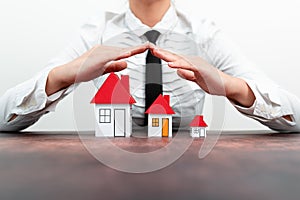 Protecting Hands Over House - Home Security And Protection Concept. hands holding paper