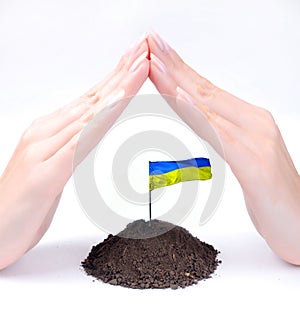 Protecting Ukraine by hands of woman at white background