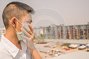 Protection against contagious disease, coronavirus. Asian young boy wearing hygienic mask to prevent infection