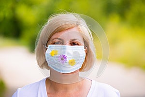 Protection against contagious disease, coronavirus, woman in hygienic face surgical medical mask with flowers to prevent