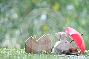 Protection, Coins money in the bag under the umbrella and model house on natural green background, Finance insurance and Safe