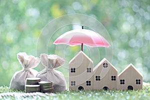 Protection, Coins money in the bag under the umbrella and model house on natural green background, Finance insurance and Safe