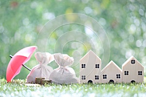 Protection, Coins money in the bag under the umbrella and model house on natural green background, Finance insurance and Safe