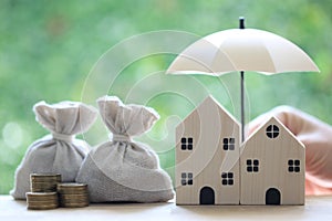 Protection, Coins money in the bag under the umbrella and model house on natural green background, Finance insurance and Safe