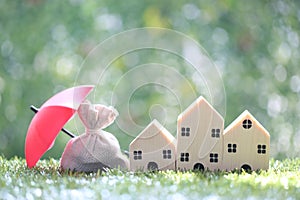 Protection, Coins money in the bag under the umbrella and model house on natural green background, Finance insurance and Safe