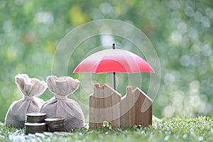 Protection, Coins money in the bag under the umbrella and model house on natural green background, Finance insurance and Safe