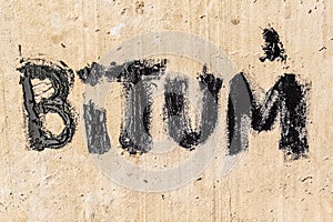 Protective bitumen mastic on concrete pavement. Bitum - black bituminous word