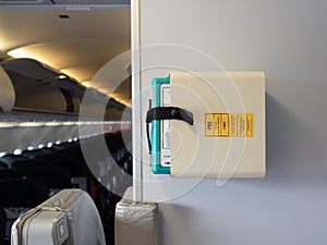 Protective breathing equipment  PBE or AVOX in aviation word  secured in stowage on aircraft wall at aft galley near cabin crew